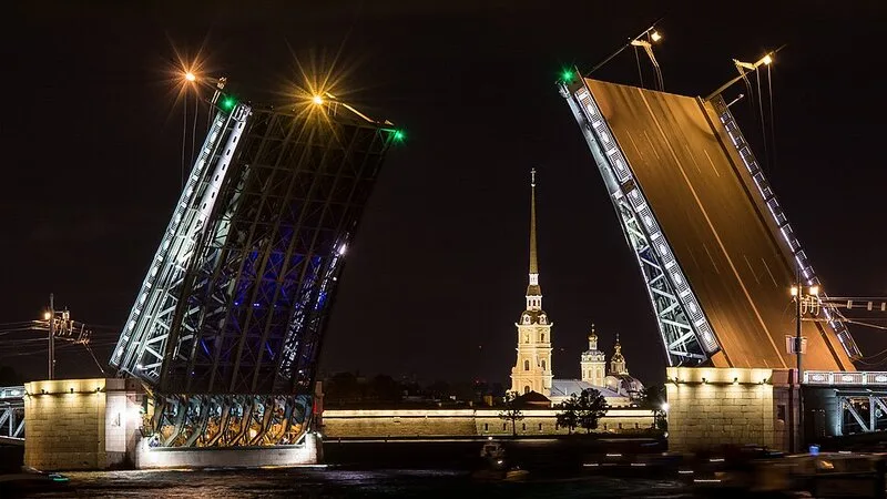 Le pont du Palais ouvert la nuit a Saint-Pétersbourg, avec vue sur la cathedrale Saint-Isaac illuminee
