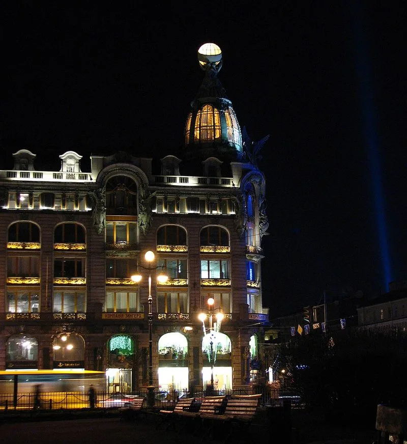 La Maison Singer illuminée de nuit sur la perspective Nevski à Saint-Pétersbourg, avec sa coupole dorée brillant dans l'obscurité